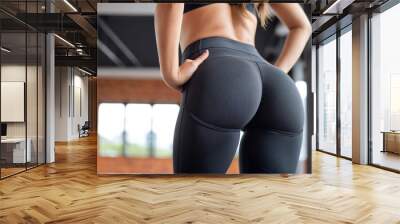 Cropped photo of a young fitness woman showing her natural curve at the gym with copy space. Wall mural