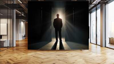 Silhouette of a businessman standing in front of a door with light coming through Wall mural