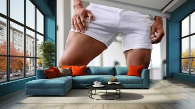 Close up man wearing white short pant show up his muscular  legs in the gym background. Man mascular thighs  Wall mural