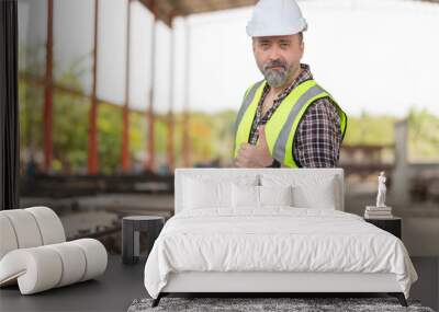 Portrait of Caucasian engineer man with doing thumbs up gesture, Cheerful foreman worker on a construction site Wall mural