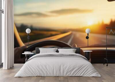 Golden Hour Road Trip: A first-person perspective of a scenic road trip at sunset, with the driver's hands gripping the steering wheel, as the road stretches ahead towards a radiant horizon.   Wall mural