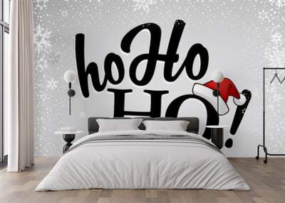 Black Ho-ho-ho! text with Santa's red hat on silver background a Wall mural