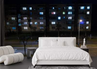 Lights of a large night city. Burning light in the Windows of the apartment. Light lines from passing cars. Wall mural