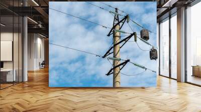 View of the tower of a high-voltage power line against the background of blue sky and clouds. Voltage power lines Wall mural