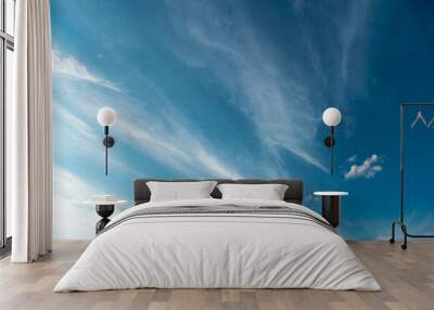 White fluffy clouds in the sky. Blue sky and cloud cover on a sunny summer day. Empty background, copy space Wall mural