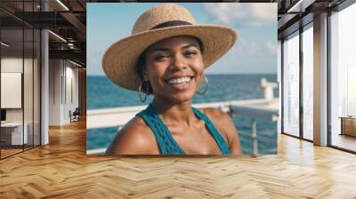 Face of happy African American woman wearing a straw hat and earrings is smiling at the camera. She is standing on a pier by the ocean Wall mural