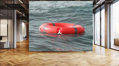 Life ring in ocean. Red lifebuoy in sea. Life ring floating in water. Red life preserver in see Wall mural