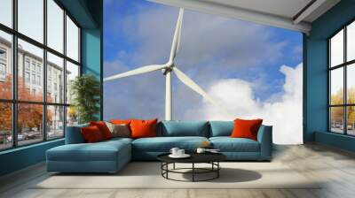 Wind stations. Windmills for electricity production. Wind turbines generating electricity against a cloudy blue sky. Energy saving concept. Wall mural