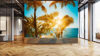 Palm trees on a beach with the blue ocean in the background in the sunrise Wall mural