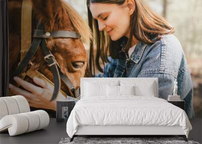 A young woman hugging a horse. Wall mural