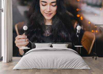 Beautiful young woman enjoying coffee cappuccino with foam near window in a cafe Wall mural