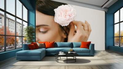 Close up portrait of beautiful young woman with pink rose flower. Wall mural