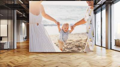 Family having fun on beach at sunset Wall mural