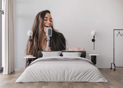 Young beautiful woman sing in vintage microphone. Wall mural