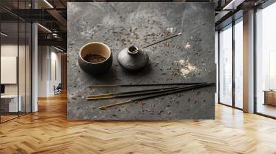 Black still life with mini vase, aroma sticks and tea cup with tea leaves  on a black texture Wall mural