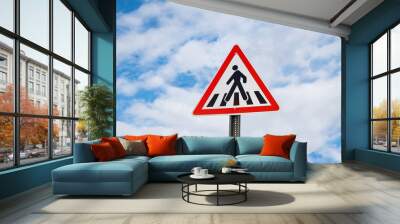 International warning traffic sign 'Pedestrian crossing' on metal pillar. Cloudy blue sky is on background Wall mural