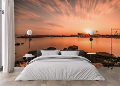 Beautiful shot of the mesmerizing sunset over the sea and a villa in the distance Wall mural