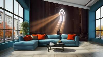 Silhouette of a man praying alone sitting in a cathedral with beam light  Wall mural