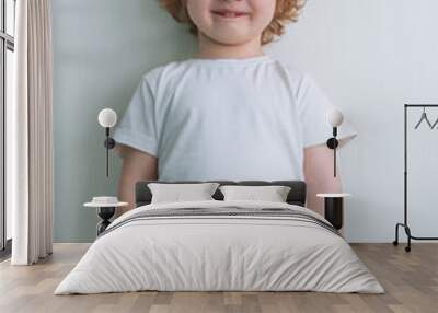 Portrait of a cute red-haired boy in a white T-shirt Wall mural