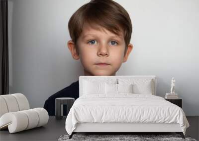 Portrait of a serious little boy on a white background Wall mural