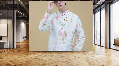 Fashion portrait of the young handsome guy posing casually wearing a Modern Traditional Lanna Dress Shirt decorative motifs. Man who upholds local values. Wall mural