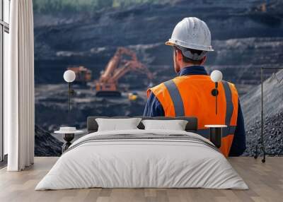 A professional wearing a hard hat and safety gear inspecting a mining site, with machinery in the background Wall mural