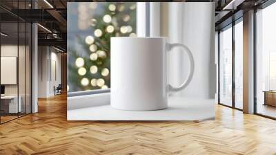 White coffee mug on a window sill with blurred Christmas tree lights in background. Wall mural