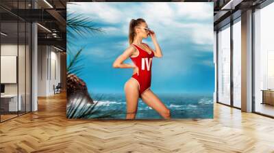 sexy young girl in red body swimsuit at the beach Wall mural