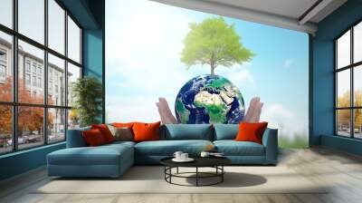 world environment and earth day, Two human hands holding big tree and earth globe over green and blue sky nature background. Elements of this image furnished by, Generative AI Wall mural