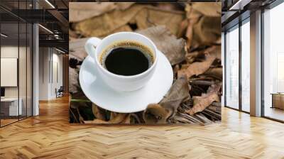 White cup of hot coffee on brown dry leaf nature background. shallow focus. Wall mural