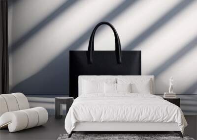 Sleek black handbag casting shadows on a minimalist background a study in modern design and style Wall mural