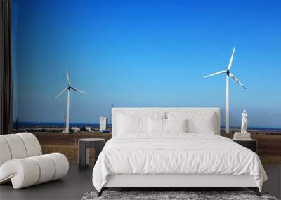 two wind turbines on a hill with sea views Wall mural