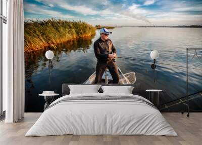 fisherman on a motor boat with spinning Wall mural