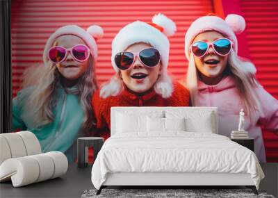 Three little charming cheerful children pose in Santa Claus costumes in a festive mood on the street in front of a solid red garage door. Generative AI. Wall mural