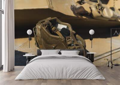 Dark-coloured military helmet lying upside down on a military US tank. Modern military equipment. High quality photo Wall mural