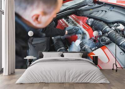 mechanic man cleaning a car engine at the workshop, indoors, car detailing. High quality photo Wall mural