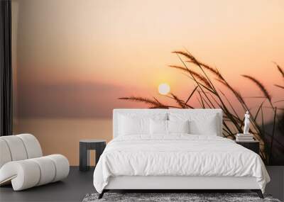 Grass and golden light at sun rise on sea Wall mural