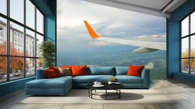 Wing of an airplane flying Wall mural