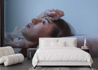 Asian women opened eyes lying on the bed have an insomnia problems. Wall mural