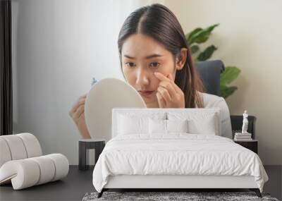 asian young woman using medical eye drops to treat dry eye and irritation. Wall mural