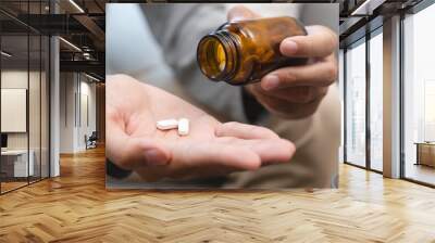 Close-up a medicine tablet in young man hand taking painkiller Wall mural