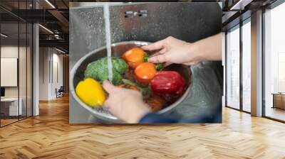 Close up of hands people washing vegetables by tap water at the sink in the kitchen to clean ingredient prepare a fresh salad. Wall mural