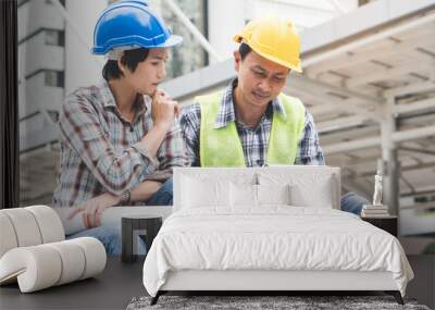 Construction builder teamwork work concept. Top view of engineer and architect planning work. male foreman pointing on blueprint explaining job to co worker in construction site. Wall mural