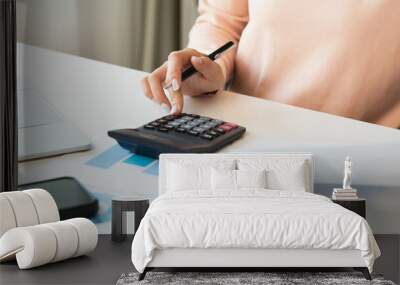 Deduction planning, debt asian young woman  hand using calculator to calculating money balance from bill and income, cost budget expenses for pay money form personal individual on table at home. Wall mural