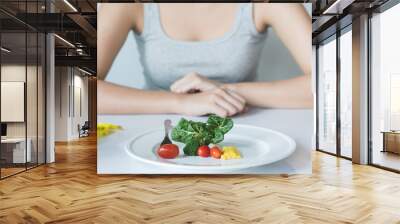 Eat less and eat healthy. person eating vegetable in dinner during control calories on dieting. Wall mural