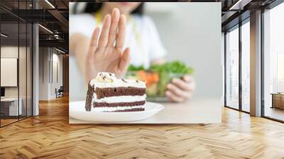 eat less sugar for health, women avoid to eat chocolate cake and sweets during sugar diet session for lose weight Wall mural