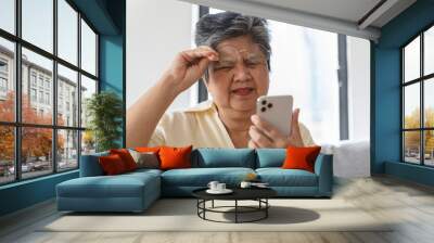 Elderly woman have eyesight problem can not read because seeing text blurred and headache from eye tired. Wall mural