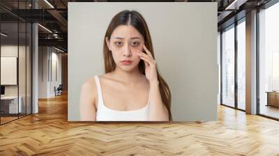 lack of sleep problem, Worried Asian young woman pointing finger at dark circles under her eyes Wall mural