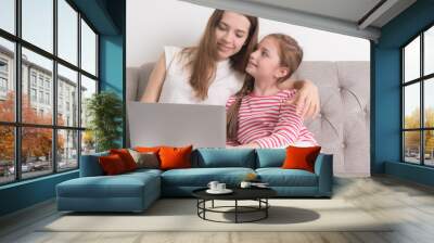 Relationship of mother and daughter concept. Mom and little girl using laptop computer to play game togethers in weekend at home. Wall mural