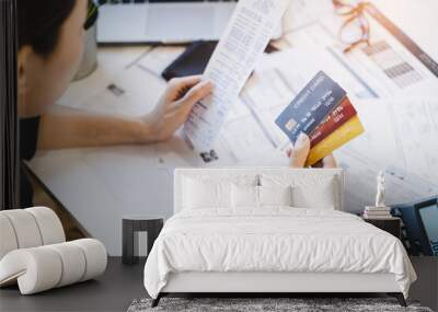 Sad Asian woman looking at many credit cards in her hand and worried about loan debt pay late. Wall mural